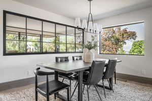 Dining space with a healthy amount of sunlight, hardwood / wood-style flooring, and a chandelier