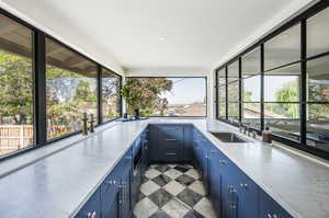 Kitchen featuring a healthy amount of sunlight, sink, and blue cabinetry