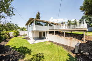 Back of property featuring a yard and a deck