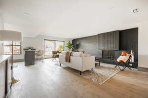 Living room featuring a multi sided fireplace and light hardwood / wood-style flooring