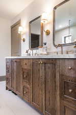 Bathroom featuring tile floors and dual bowl vanity