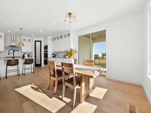 Dining room featuring light wood-type flooring and a chandelier