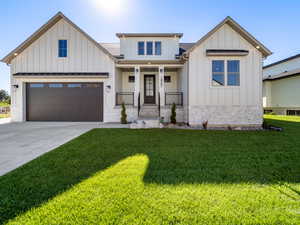 Modern inspired farmhouse with a front lawn, a porch, and a garage