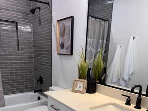 Full bathroom featuring shower / tub combo, vanity, tile patterned flooring, and toilet