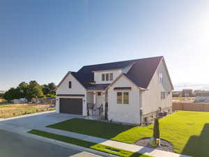 Modern farmhouse style home with central air condition unit, a garage, and a front lawn