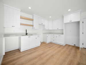 Kitchen featuring light hardwood / wood-style floors and white cabinetry