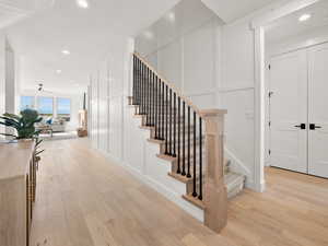 Stairs with ceiling fan and hardwood / wood-style flooring