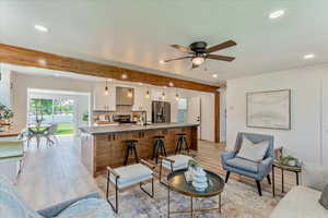 Living room with light hardwood / wood-style floors, sink, and ceiling fan