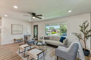 Living room featuring ceiling fan and light hardwood / wood-style floors