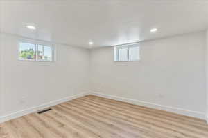 Basement with light wood-type flooring