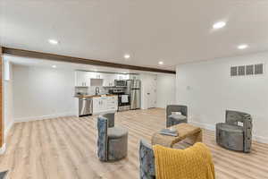 Living room with sink and light wood-type flooring