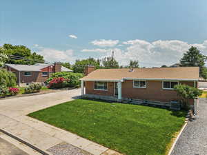 View of front of home with central AC and a front lawn