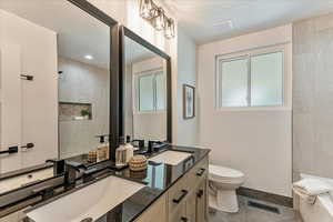 Bathroom with plenty of natural light, tile flooring, toilet, and vanity