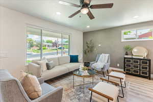 Living room with wood-type flooring and ceiling fan