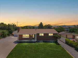 Ranch-style house featuring a garage and a lawn