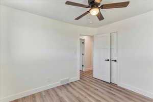 Empty room featuring light wood-type flooring and ceiling fan