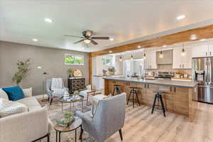 Living room featuring ceiling fan, light hardwood / wood-style floors, and sink