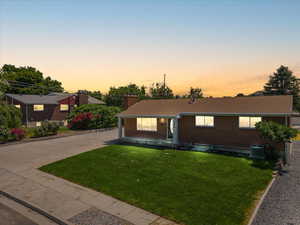 Ranch-style home featuring central AC and a yard