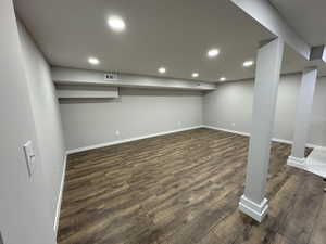 Basement with dark hardwood / wood-style flooring