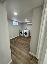 Laundry room featuring dark hardwood / wood-style floors, hookup for a washing machine, separate washer and dryer, and a textured ceiling