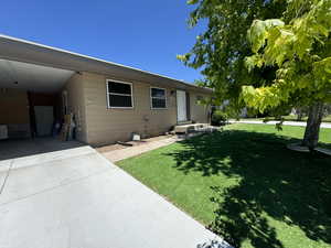 Rear view of house with a carport and a yard