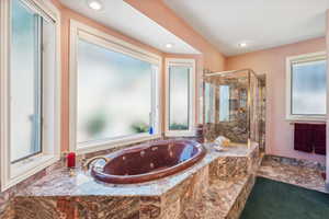 Bathroom featuring tile flooring, plenty of natural light, and plus walk in shower