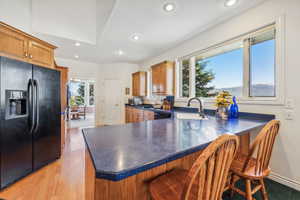 Kitchen featuring black appliances, a wealth of natural light, sink, and light wood-type flooring