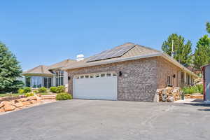 Ranch-style home with a garage and solar panels