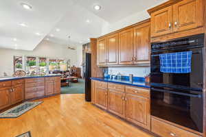 Kitchen featuring ceiling fan, light hardwood / wood-style floors, and black appliances