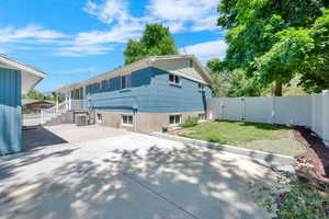 Back of property with a lawn and a patio fenced