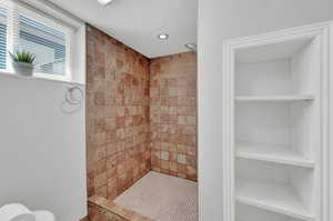 Bathroom with a tile shower and built in shelves