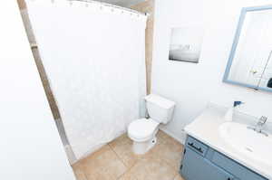 Bathroom with tile floors, oversized vanity, and toilet