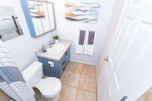 Bathroom featuring tile flooring, toilet, and vanity