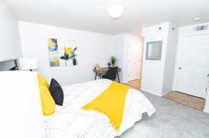 Carpeted bedroom featuring two (2) closets and master bath