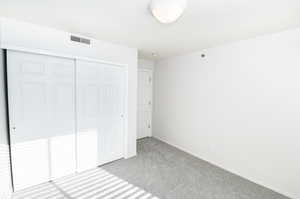 Unfurnished bedroom with carpet and a closet