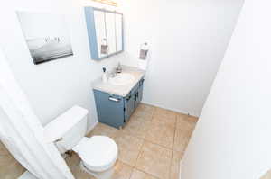 Bathroom with vanity, toilet, and tile floors