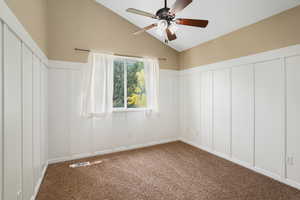 Carpeted spare room with high vaulted ceiling and ceiling fan