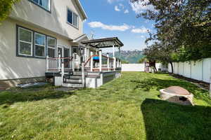 View of yard featuring a deck and an outdoor fire pit