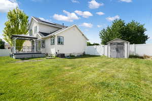 Rear view of property featuring a shed, central AC, a lawn, and a gazebo