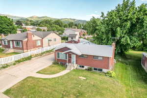 View of front of house with a mountain view and a front lawn