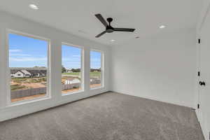 Carpeted spare room with ceiling fan