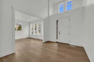 Foyer featuring hardwood / wood-style floors and a towering ceiling