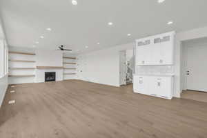 Unfurnished living room with ceiling fan and light hardwood / wood-style floors