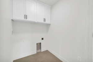 Laundry room with hookup for an electric dryer, tile patterned floors, and cabinets