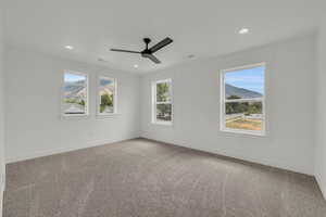 Carpeted spare room featuring ceiling fan