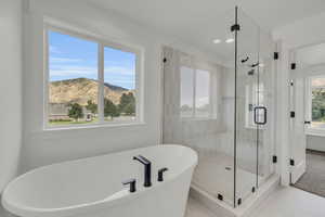 Bathroom with a wealth of natural light, plus walk in shower, and tile patterned floors