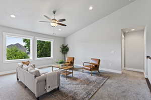 Living room with high vaulted ceiling, carpet, and ceiling fan