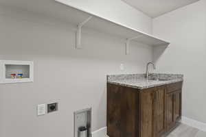 Laundry room featuring sink, washer hookup, and hookup for an electric dryer