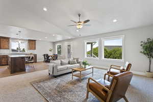 Living room with plenty of natural light, ceiling fan, light wood-type flooring, and high vaulted ceiling