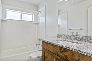 Full bathroom with shower / bath combination, oversized vanity, and toilet